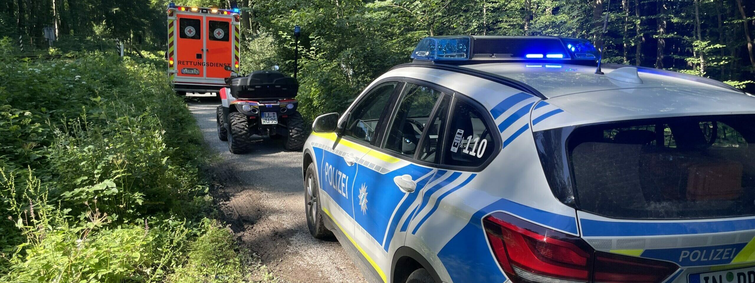 Rettungswagen und Wasserwacht-Quad und Polizei BMW-X1 um Wald Seeholz Riederau
